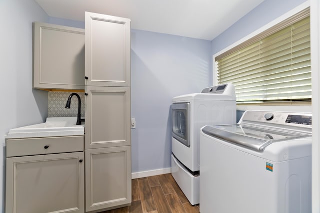 laundry room with cabinets, independent washer and dryer, and sink