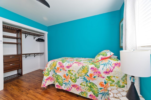 bedroom with ceiling fan, dark hardwood / wood-style flooring, and a closet