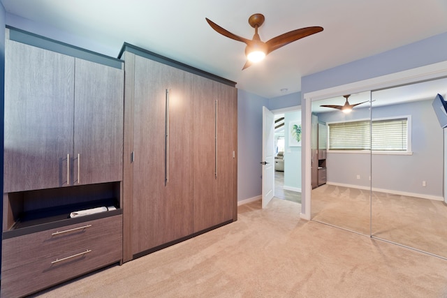 unfurnished bedroom featuring light carpet, a closet, and ceiling fan