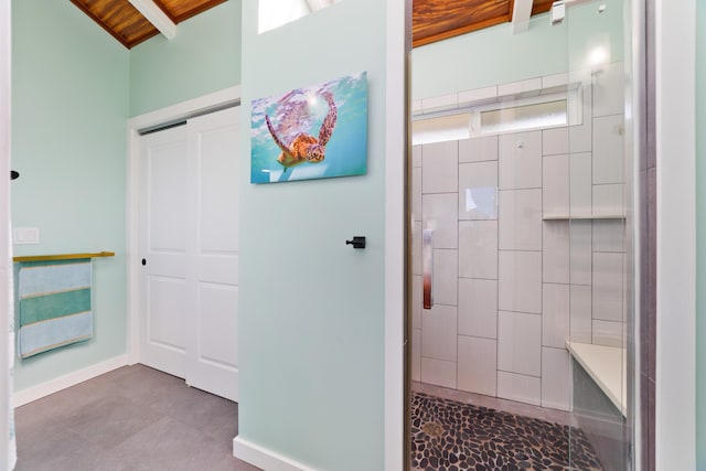 bathroom with lofted ceiling with beams, tiled shower, and wood ceiling