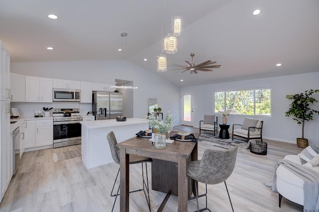 dining area with ceiling fan, light hardwood / wood-style floors, and lofted ceiling