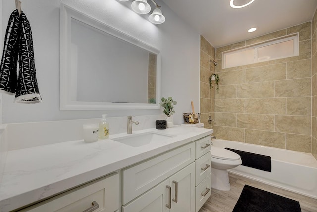 full bathroom featuring wood-type flooring, vanity, toilet, and tiled shower / bath