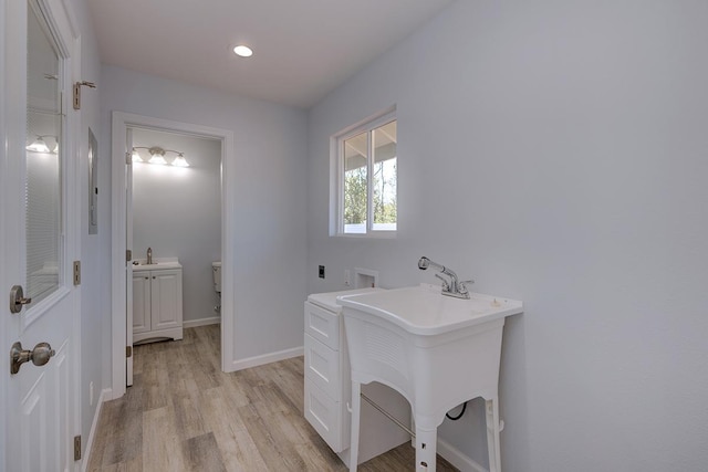 bathroom with hardwood / wood-style floors, toilet, and sink