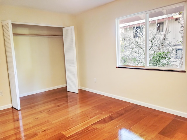 unfurnished bedroom with wood-type flooring and a closet