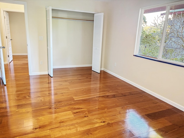 unfurnished bedroom with hardwood / wood-style flooring and a closet