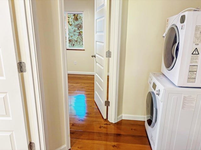 washroom featuring stacked washer / dryer and dark wood-type flooring