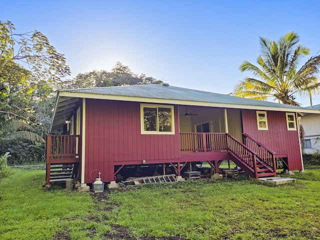 rear view of property with a yard and ceiling fan