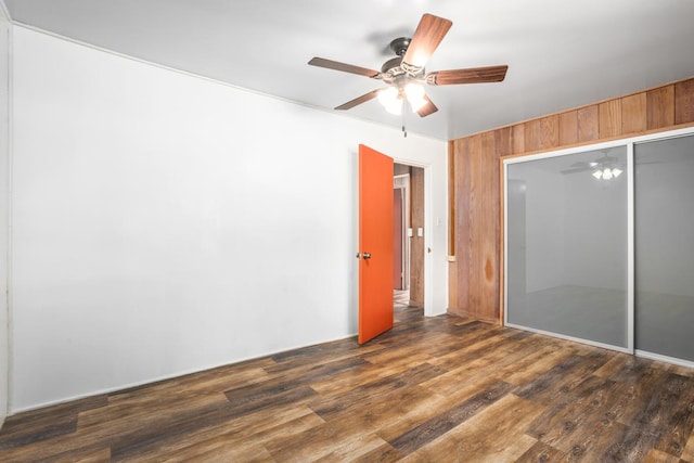 unfurnished bedroom with dark hardwood / wood-style flooring, ceiling fan, and a closet