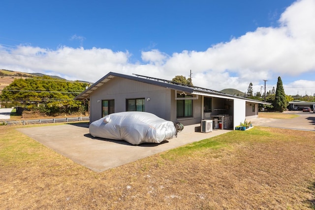 exterior space featuring a front lawn, a patio, and cooling unit