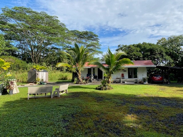 view of yard featuring a storage shed and a carport