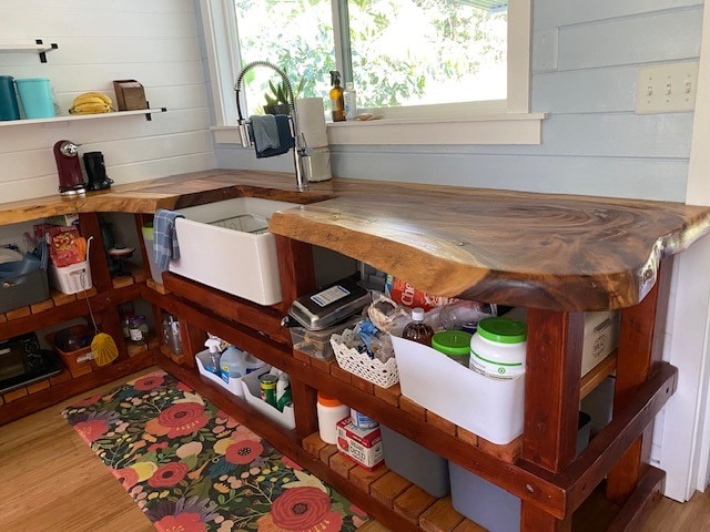 room details with sink, wood walls, and hardwood / wood-style floors