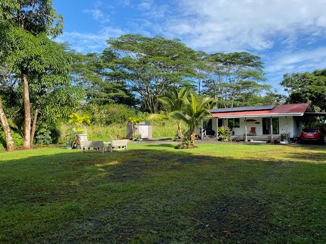 view of yard with covered porch and a shed