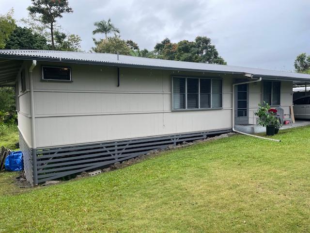 view of side of home with a lawn and a carport