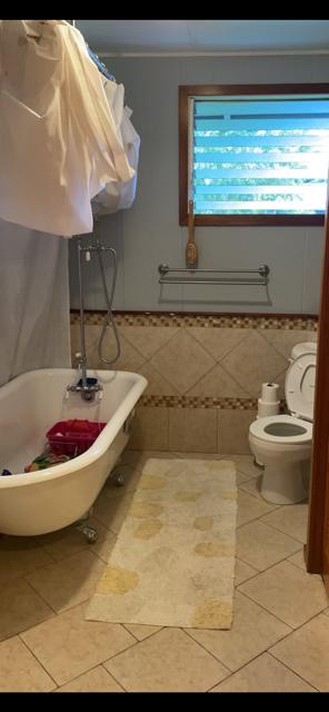 bathroom with toilet, a tub, tile patterned flooring, and a healthy amount of sunlight