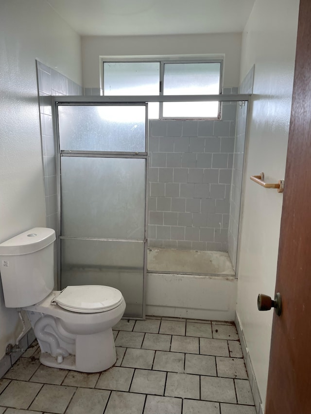 bathroom featuring toilet and combined bath / shower with glass door