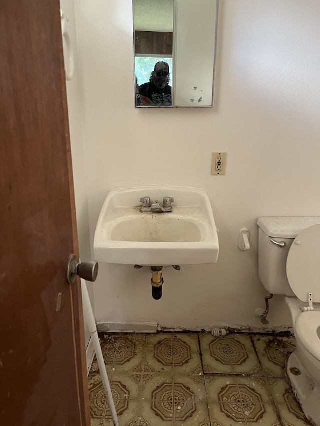 bathroom with sink, toilet, and tile patterned floors