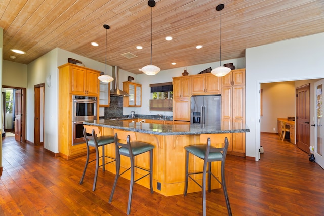 kitchen with a large island with sink, stainless steel appliances, a kitchen breakfast bar, hanging light fixtures, and wooden ceiling