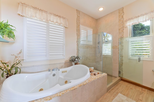 bathroom featuring separate shower and tub, a wealth of natural light, and hardwood / wood-style floors