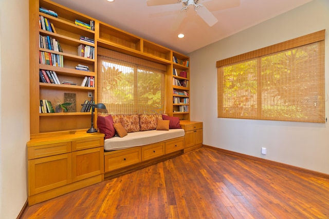 living area with ceiling fan and dark hardwood / wood-style floors