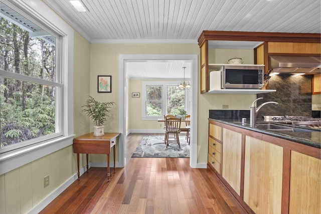 kitchen with crown molding, sink, an inviting chandelier, dark hardwood / wood-style floors, and range hood