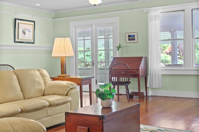 sitting room with wood-type flooring, crown molding, and a wealth of natural light