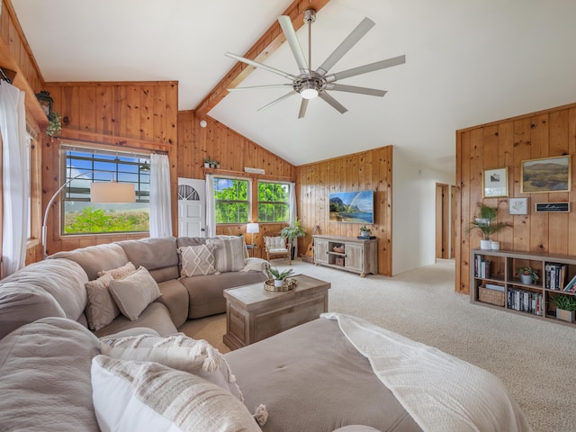 carpeted living room featuring beamed ceiling, high vaulted ceiling, ceiling fan, and wood walls