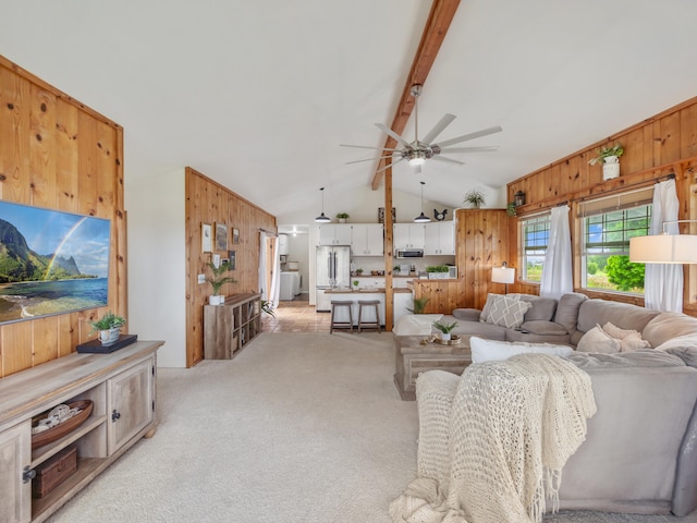 carpeted living room with vaulted ceiling with beams, ceiling fan, and wooden walls