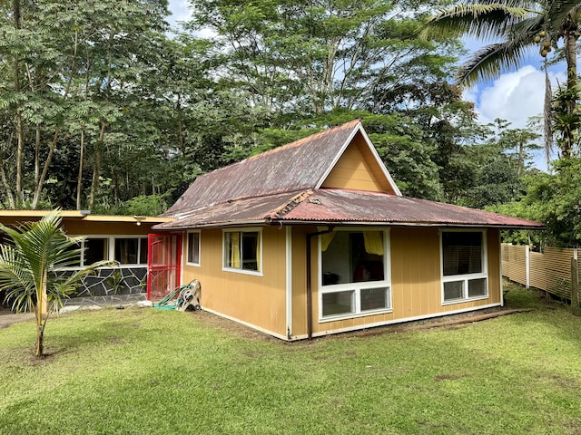 back of property with an outdoor structure and a lawn