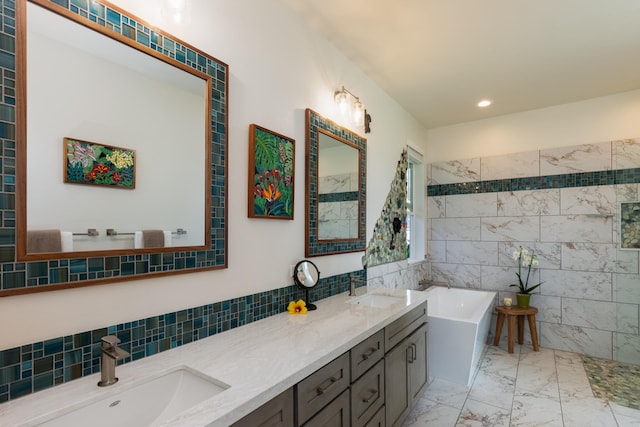 bathroom with vanity, a tub, and tile walls