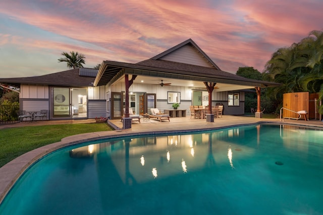 pool at dusk featuring a patio area and ceiling fan