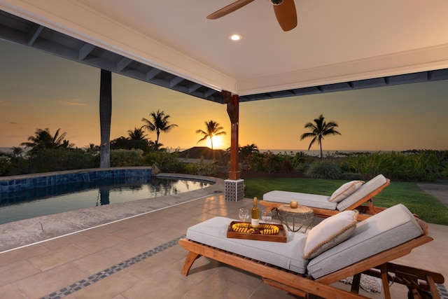 pool at dusk featuring a patio and ceiling fan