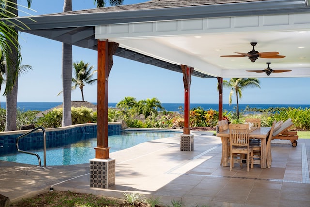 view of pool with a patio, ceiling fan, and a water view