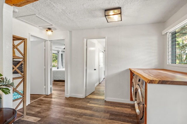 corridor featuring dark hardwood / wood-style flooring, a textured ceiling, and independent washer and dryer