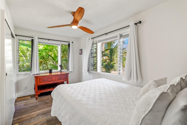 bedroom featuring a textured ceiling, ceiling fan, and dark hardwood / wood-style floors