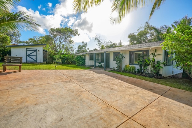 back of property featuring a yard and a storage shed