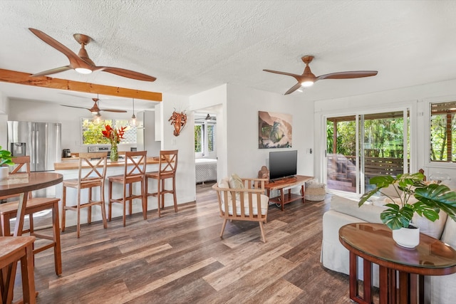 living room featuring ceiling fan, radiator heating unit, dark wood-type flooring, and a textured ceiling