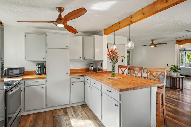 kitchen with kitchen peninsula, pendant lighting, white cabinets, butcher block counters, and stainless steel electric range