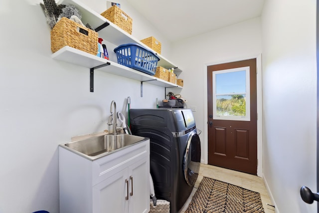 laundry area featuring washer and dryer, cabinets, and sink