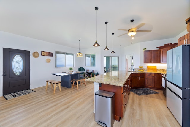 kitchen featuring ceiling fan, sink, light stone countertops, light hardwood / wood-style flooring, and white fridge