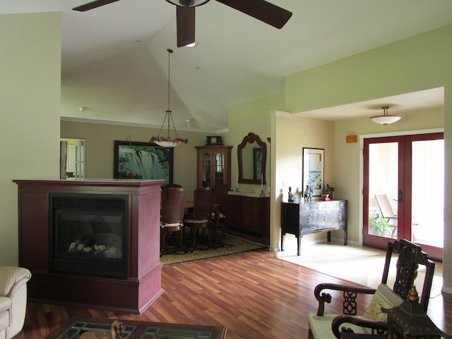 living room with ceiling fan, wood-type flooring, french doors, and vaulted ceiling