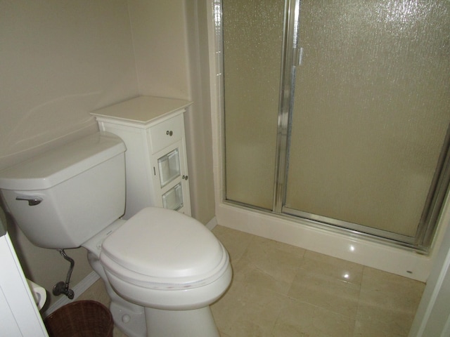 bathroom featuring tile patterned flooring, toilet, and an enclosed shower