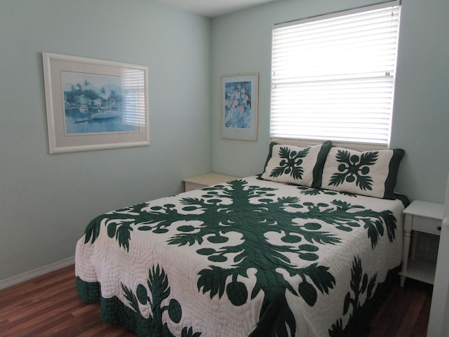 bedroom with multiple windows and dark wood-type flooring