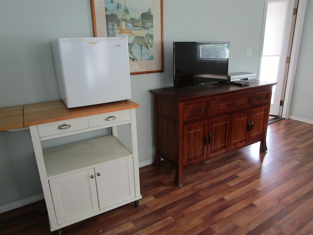 interior space with dark hardwood / wood-style floors and white fridge