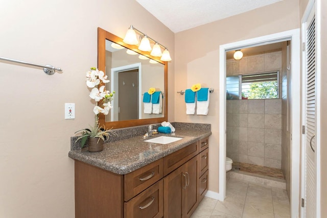 bathroom featuring tile patterned floors, vanity, toilet, and a textured ceiling