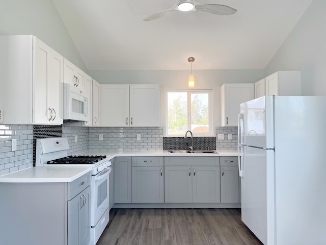 kitchen featuring pendant lighting, white appliances, white cabinets, sink, and vaulted ceiling