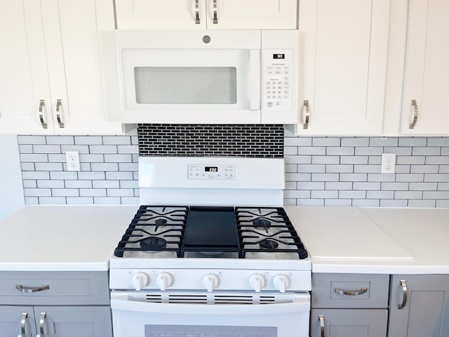 kitchen with decorative backsplash, white appliances, white cabinets, and gray cabinetry