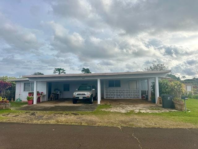 ranch-style home with a carport and a front lawn