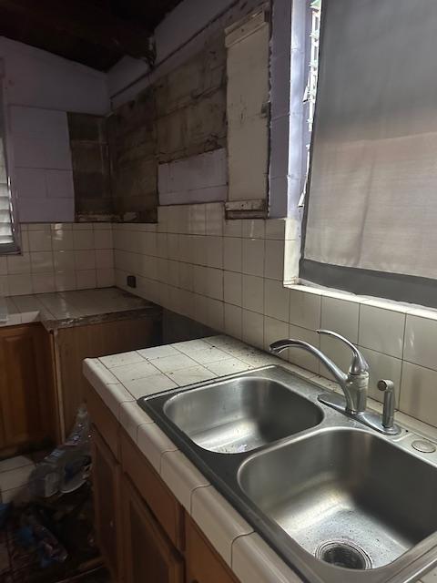 kitchen featuring tasteful backsplash, sink, and tile countertops