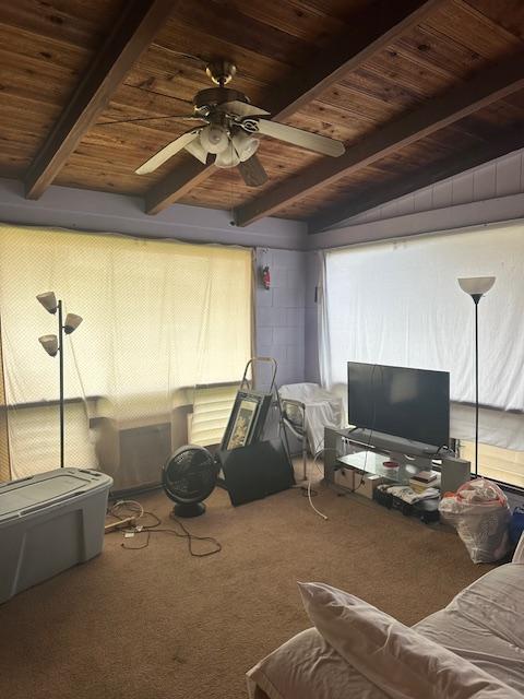 living room with beamed ceiling, ceiling fan, carpet flooring, and wood ceiling