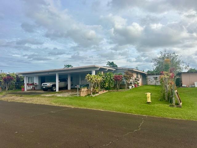 manufactured / mobile home featuring a carport and a front yard